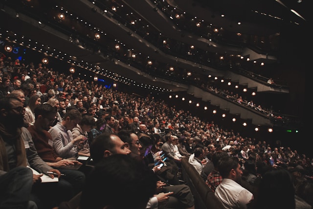 A big audience sits and waits for the theater performance to start.