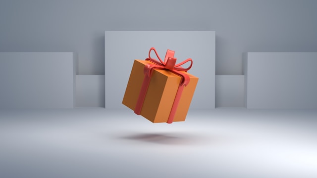 An orange gift box with a red ribbon.