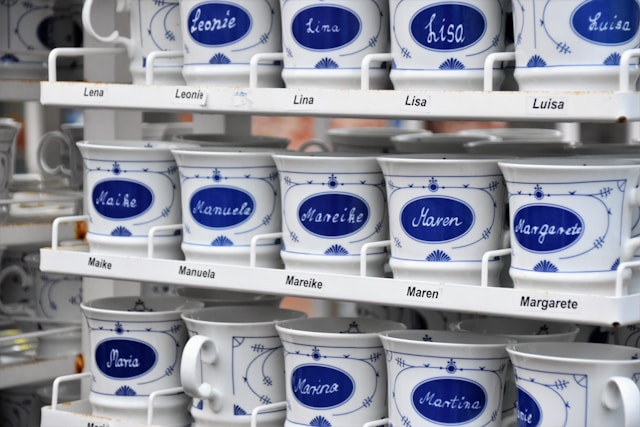 Rows of blue and white mugs with different names.