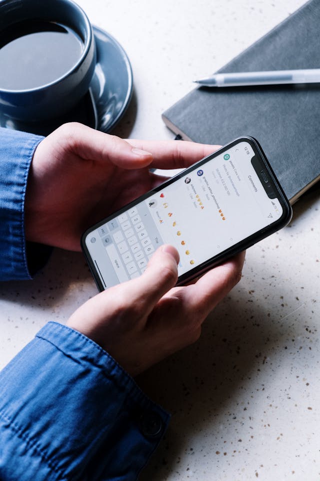 A person holds a cell phone with two hands.