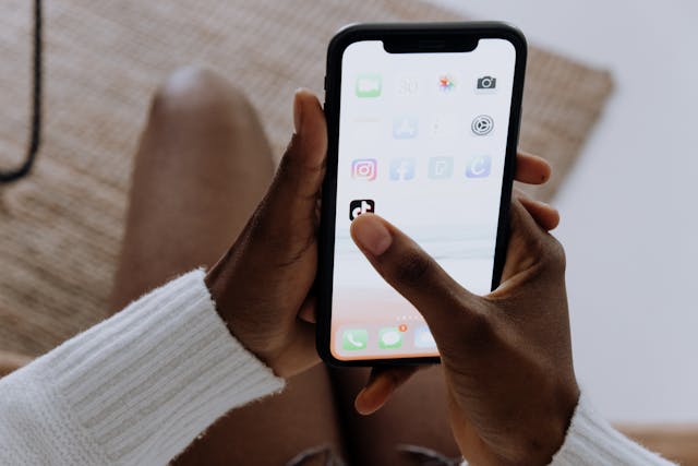 Someone highlights the TikTok app on the iPhone's home screen.