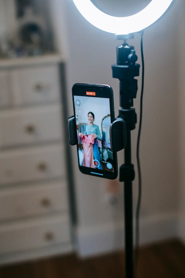 A cell phone records a woman showing off clothes.