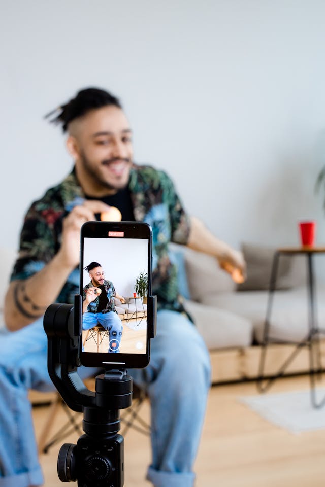 A phone records a man with balls in his hand.