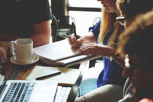 Several people brainstorm for a business over a desk.