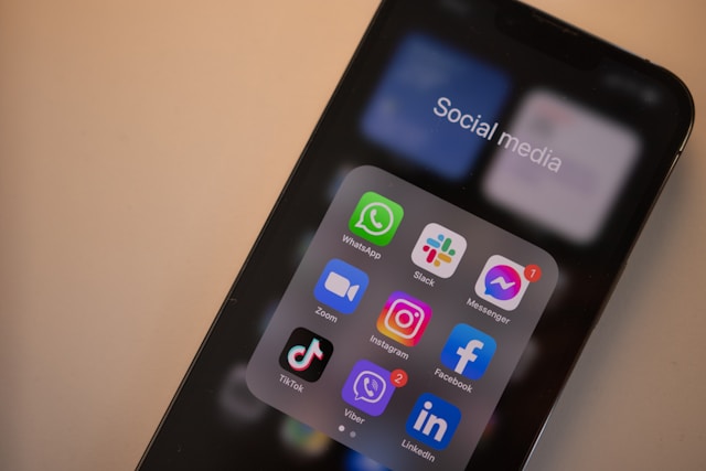 A phone screen displays popular social media apps.