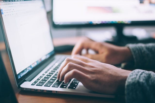 A person types on their laptop.